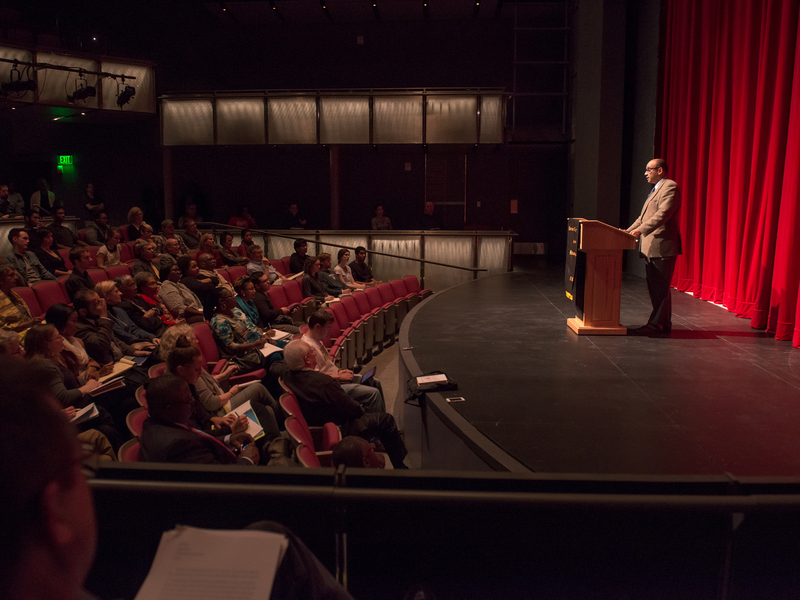 Kwame Anthony Appiah standing at a podium and speaking to an audience.